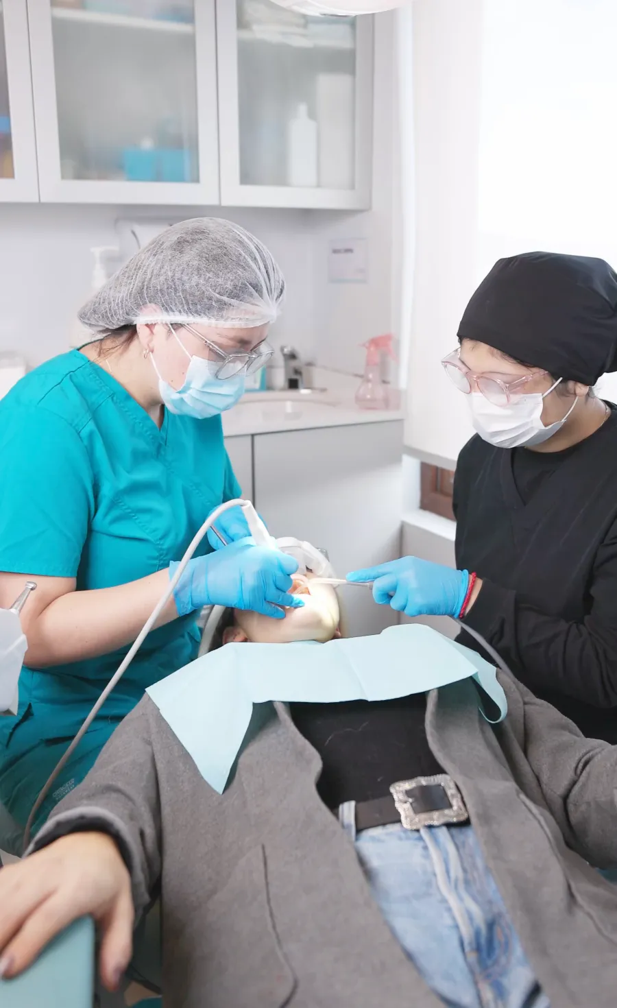 Dos profesionales atendiendo a una paciente adulta que recibe óxido nitroso con mascarilla nasal